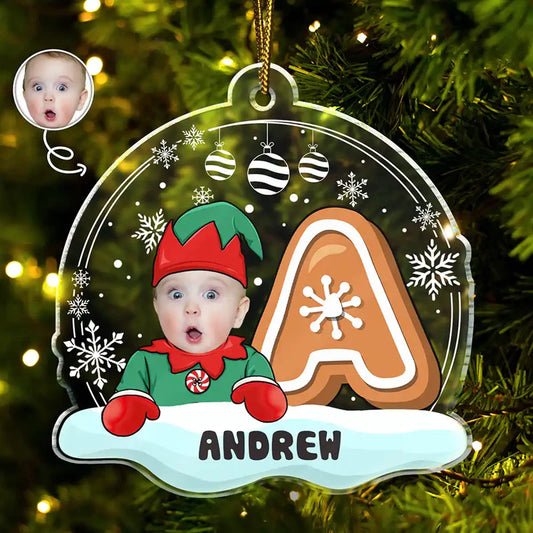 Christmas ornament with a child in an elf costume, gingerbread man, and snowflakes on a tree.